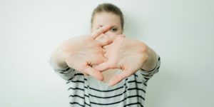 a woman making a heart with her hands